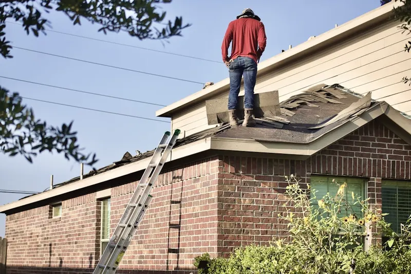 Professional roofer working on a residential roof in Carmichael Colony